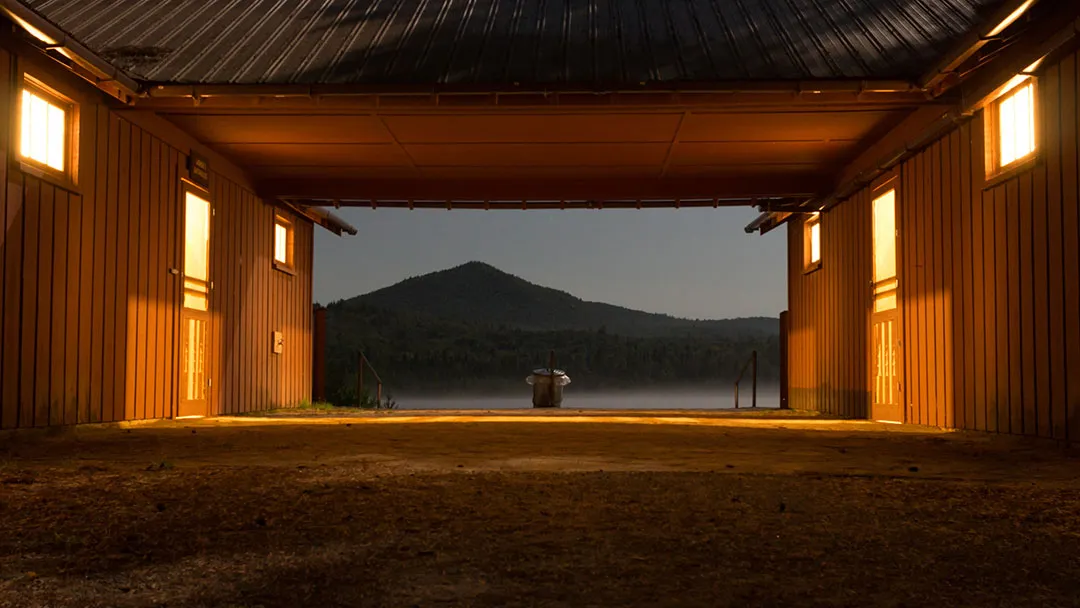 Low light, long exposure. Looking between two buildings with a garbage can in the middle and mountains in the background