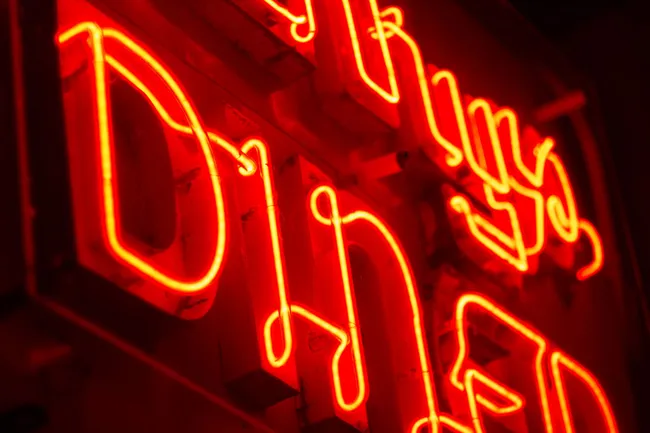 Neon sign at night that says “Henry’s Diner”.