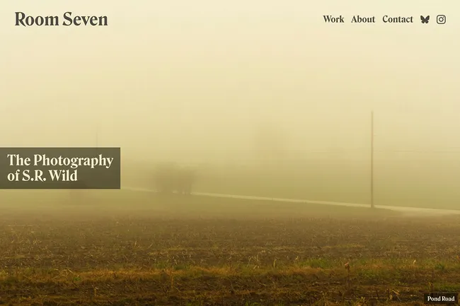 Screenshot of a web site with Room Seven in the upper left corner and a navigation to the right of it. In the middle-right is a large headline, The Photography of S.R. Wild. There’s an image that fills the screen of a yellow tinted photography looking across a field, bisected by a road with telephone poles that disappear into the fog.